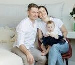 A joyful family moment with parents and their baby, captured in a cozy home environment.